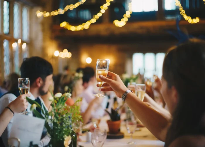 Premier Staff team members raising glasses in a celebratory toast at an elegant indoor event, capturing a moment of camaraderie and celebration.